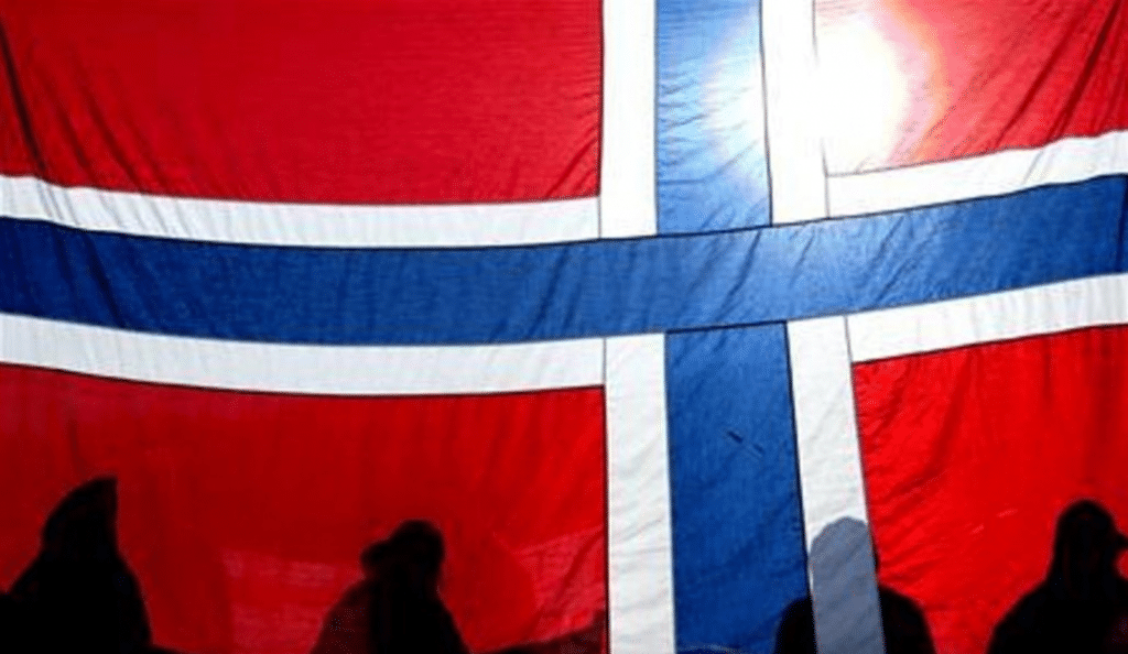 Alcune persone a Oslo, dietro una bandiera della Norvegia