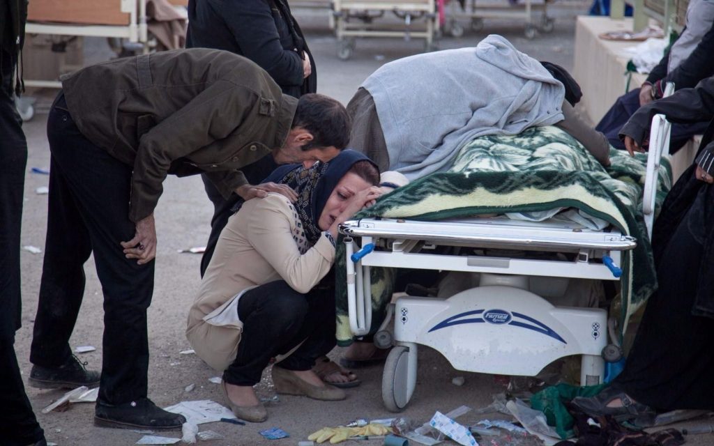 Cittadini iraniani piangono le loro vittime dopo il terremoto.