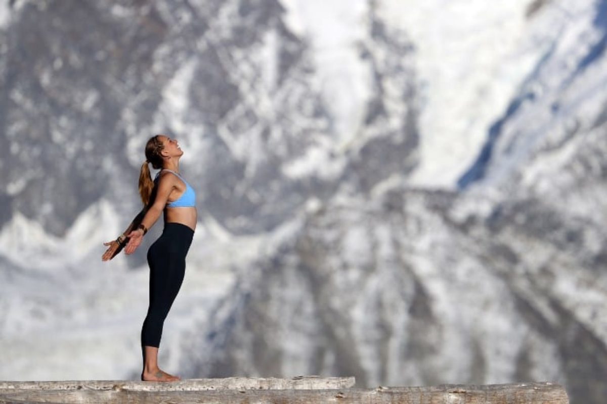 French Alps. Mont-Blanc massif. Woman doing yoga meditation on mountain. Saint-Gervais. France.